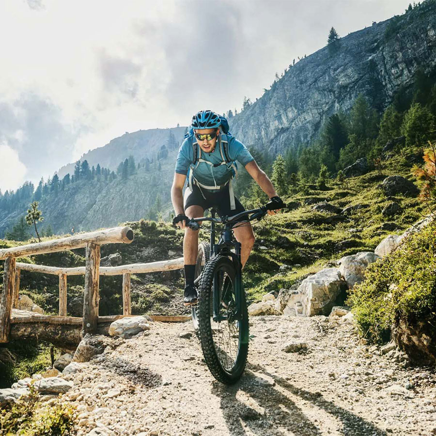 Young Guy Riding a Mountain Bike on a Gravel Trail