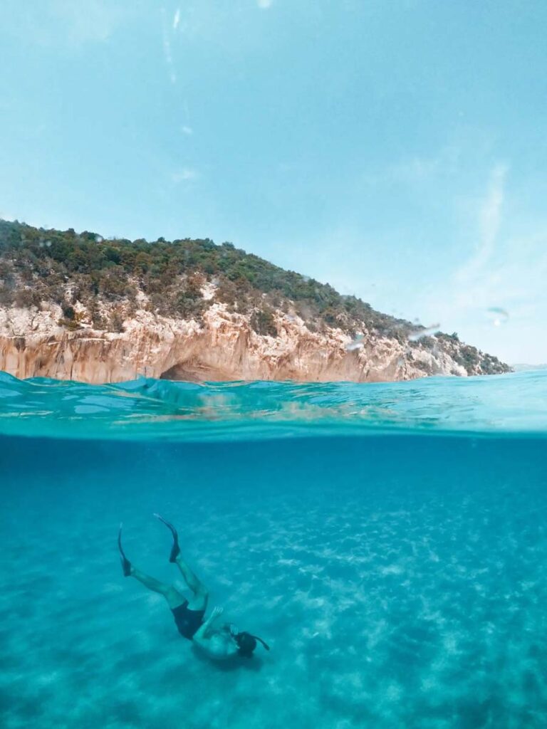 Young man swimming under crystal blue water