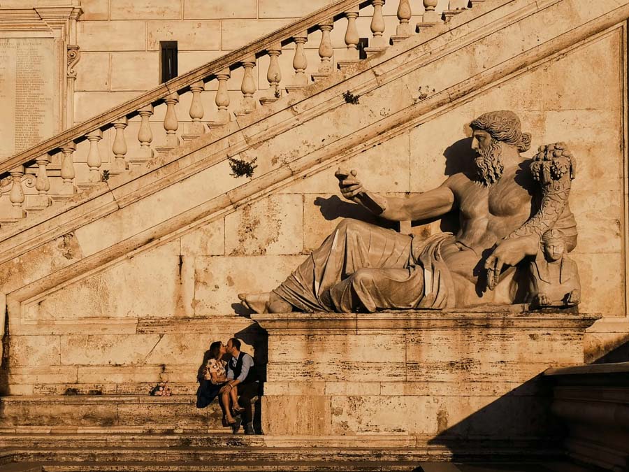 Couple kissing sitting on Statua del Dio Nilo in Rome